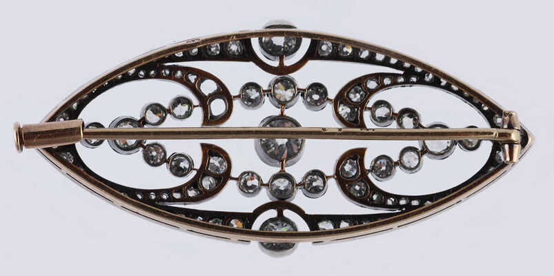 Брошь из желтого и белого металла, общим весом 7,82 грамма, содержит природные вставки из бриллиантов